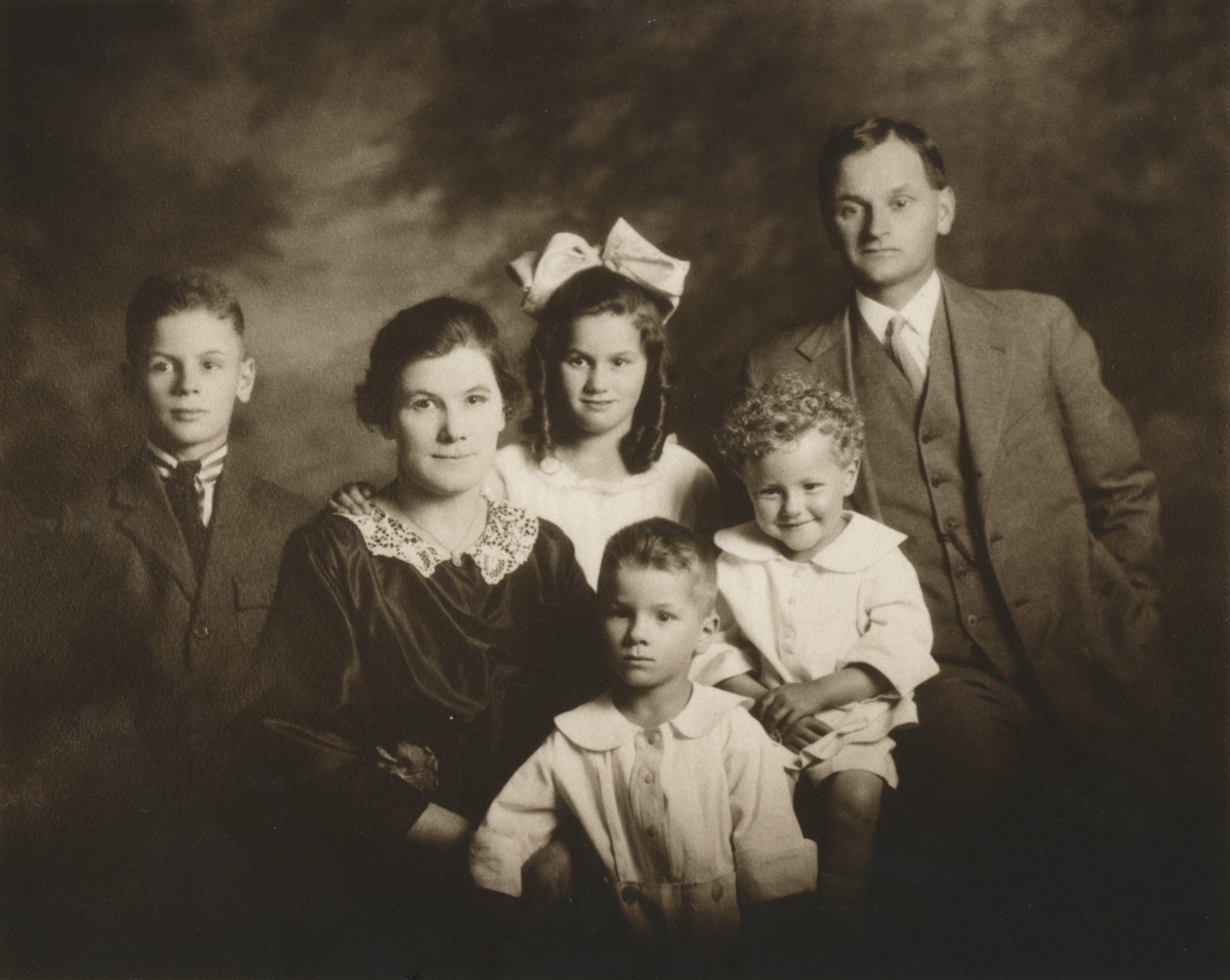 Dad as young boy standing in front with family Lost and Finding Faye Clover Flowers